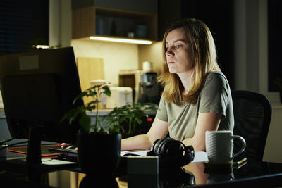 Tired woman works at home workplace