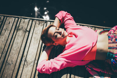 Rear view of young woman standing against wall