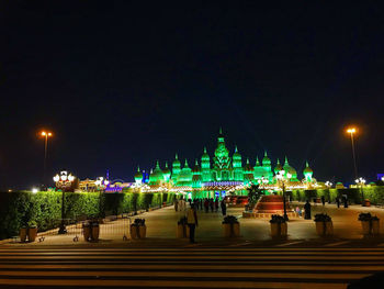 View of illuminated street against buildings at night