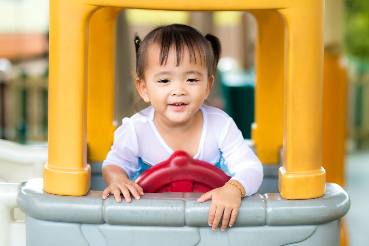 PORTRAIT OF SMILING BOY PLAYING IN PLAYGROUND