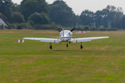 Airplane on airport runway against sky