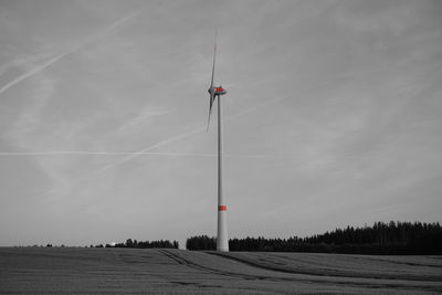 Low angle view of windmill on field against sky