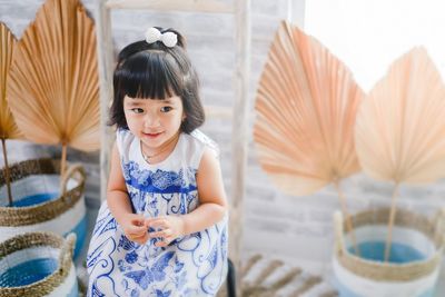Cute girl standing against wall