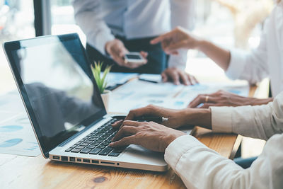 Group of people using laptop on table