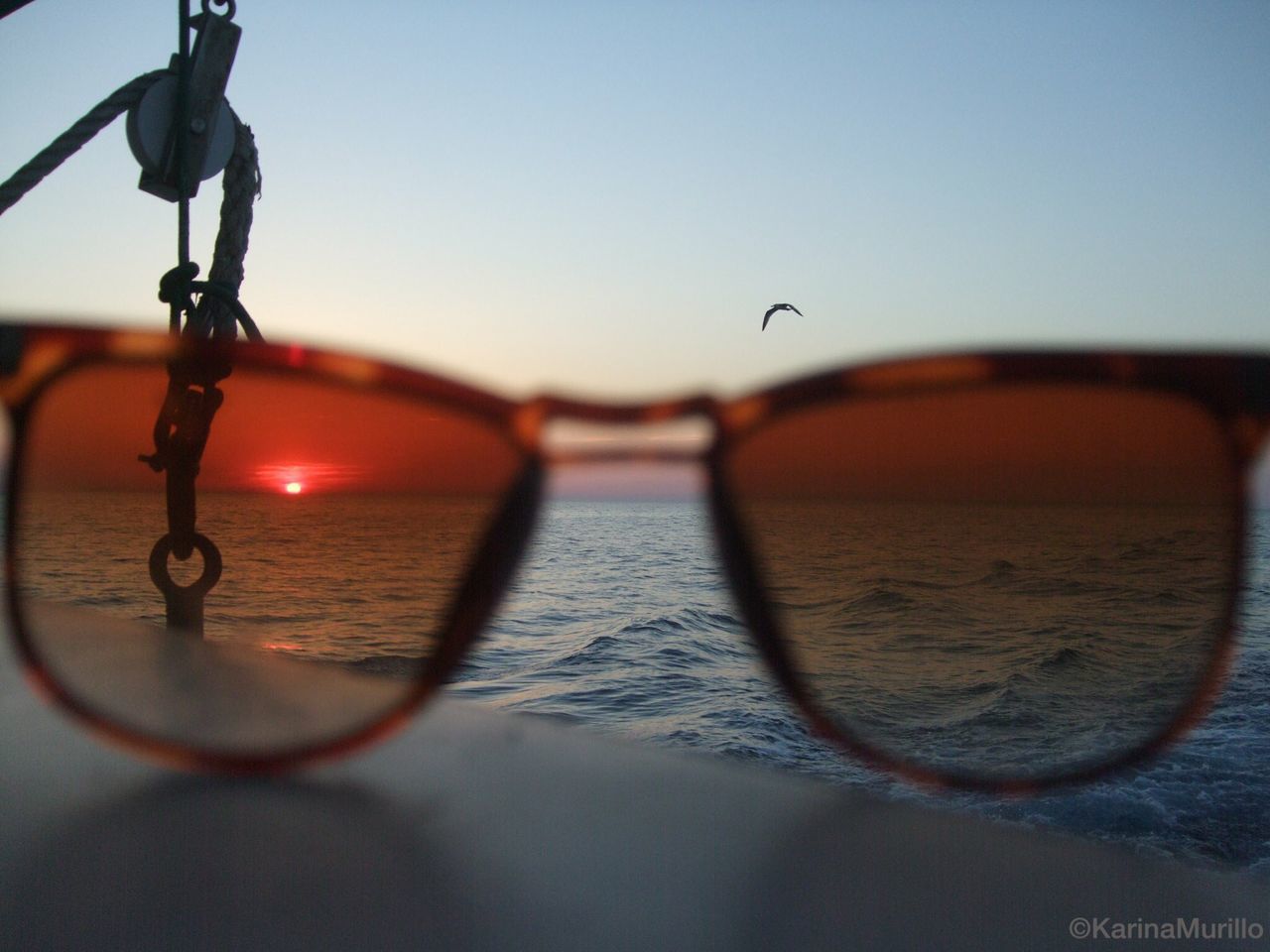 focus on foreground, water, sunset, close-up, clear sky, metal, sky, chain, sea, selective focus, protection, bicycle, safety, silhouette, outdoors, no people, transportation, reflection, tranquility, nature