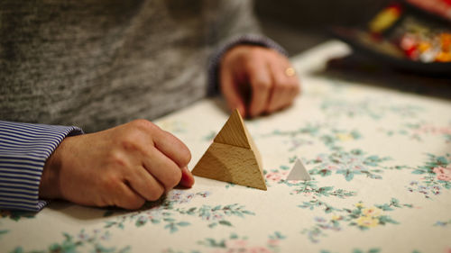 Close-up of man holding paper on table