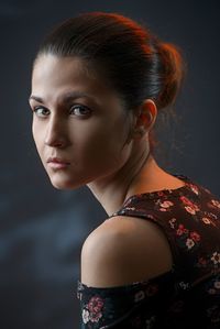 Portrait of beautiful young woman against black background