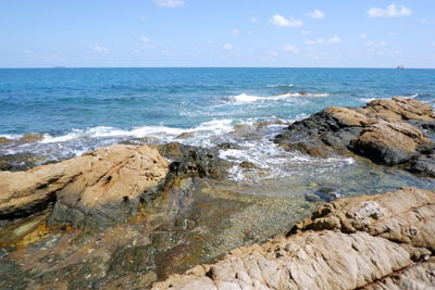 Scenic view of rocks on beach against sky