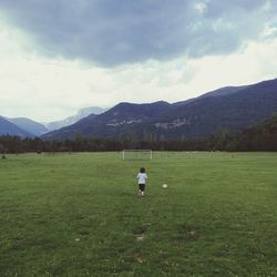 Scenic view of grassy field against cloudy sky