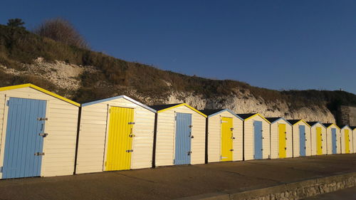 Row of beach huts against clear sky