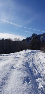 Snow covered field against blue sky