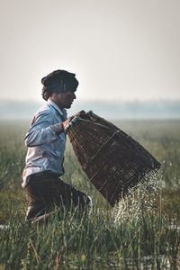 Side view of boy on field against clear sky