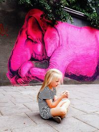 High angle view of girl sitting outdoors