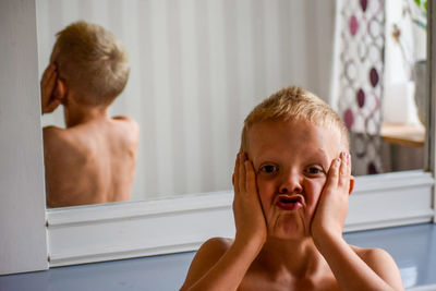 Portrait of shirtless boy in bathroom at home