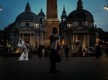 Tourists in front of building against sky