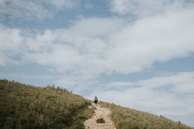 Low angle view of female hiker hiking on mountain