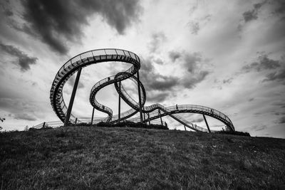 Low angle view of chain swing ride against sky