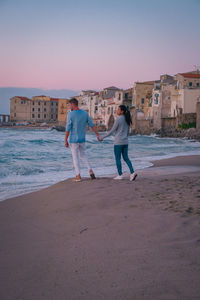 People standing on beach by sea against sky