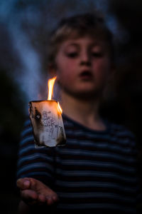 Portrait of boy holding lit candle