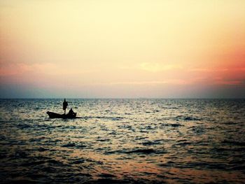 Boat sailing in sea at sunset