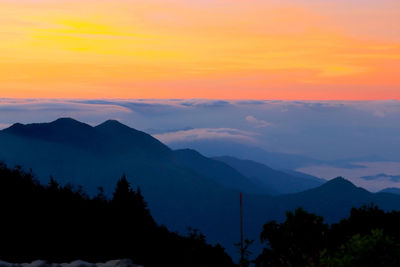 Scenic view of silhouette mountains against romantic sky at sunset