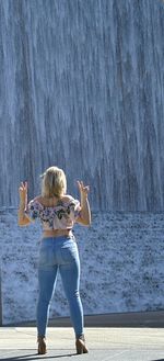 Rear view of woman with arms outstretched standing in sea