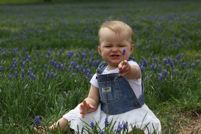 Cute baby girl sitting on field