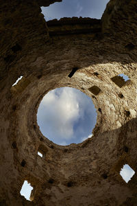 Low angle view of old building against cloudy sky