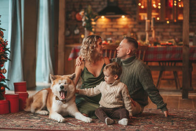 Candid authentic happy family during wintertime together enjoying holidays with dog at xmas