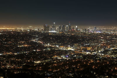 Illuminated cityscape against sky at night