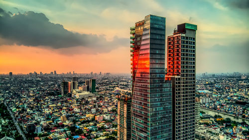 Modern buildings in city against cloudy sky