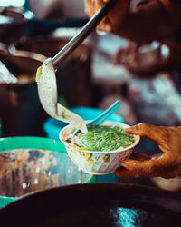 Close-up of hand holding ice cream in bowl