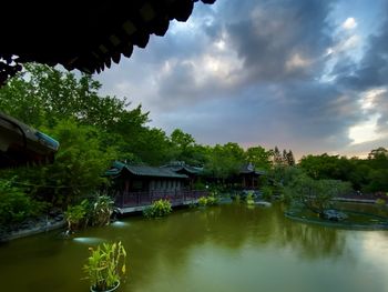 Scenic view of river by buildings against sky