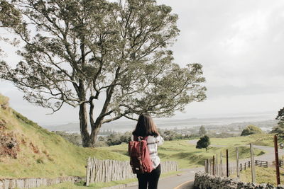 Full length of woman standing by tree against sky