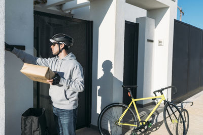 Delivery man holding package outside house