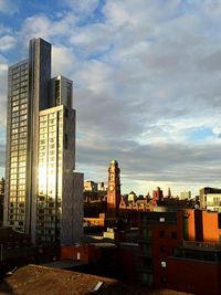 Buildings against cloudy sky