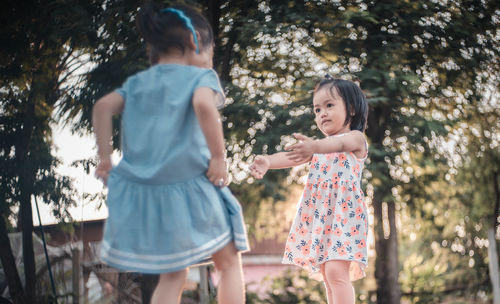 Happy girl standing against trees