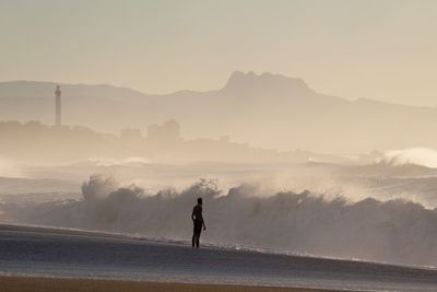 Man standing on beach against sky