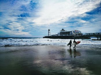 People on beach against sky