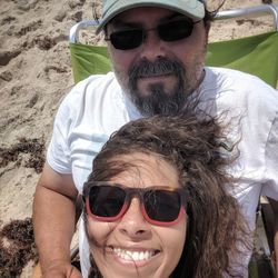 Portrait of smiling friends wearing sunglasses at beach