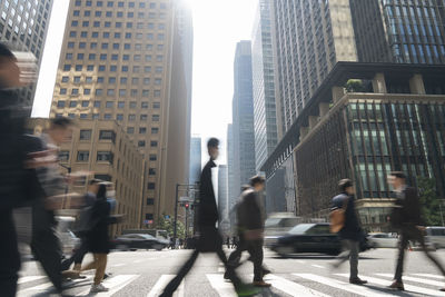 People walking on street amidst buildings in city