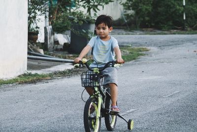 Boy riding bicycle on road