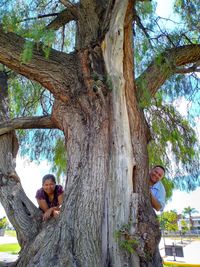 Portrait of woman sitting on tree trunk