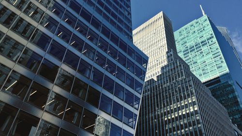 Low angle view of skyscrapers against blue sky