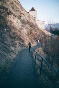 Man walking on road against clear sky