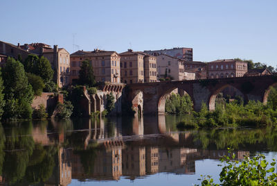 Arch bridge over river against sky