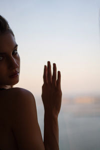 Portrait of a beautiful young woman next to the window