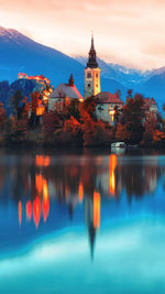 Reflection of lighthouse in lake at sunset