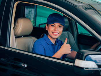 Portrait of smiling woman sitting in car