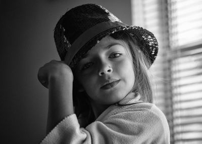 Portrait of cute girl wearing hat against wall at home